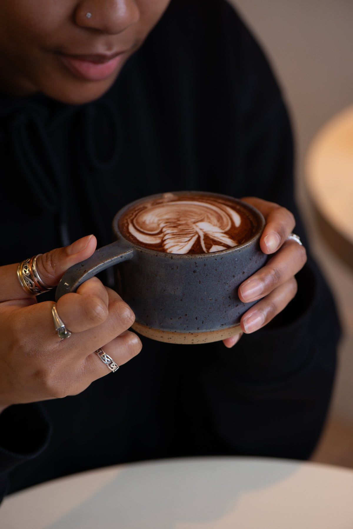 Lifestyle image of a customer enjoying Blendsmiths hot chocolate with swan latte art on top.