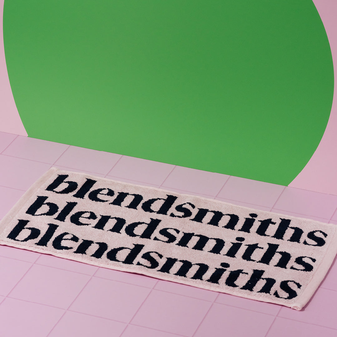 Pink Blendsmiths barista towel with navy Blendsmiths wordmark.