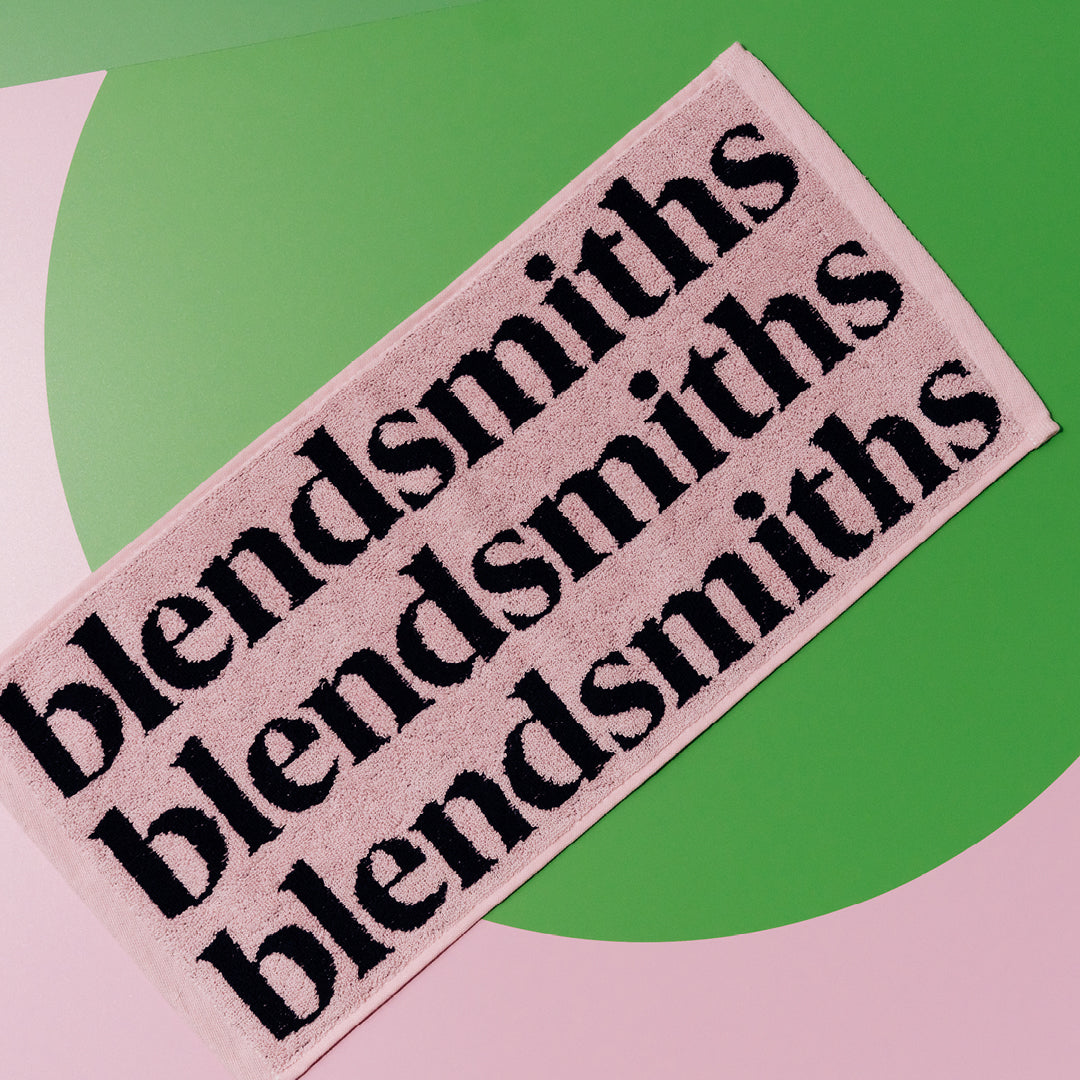 Pink Blendsmiths barista towel with navy Blendsmiths wordmark.