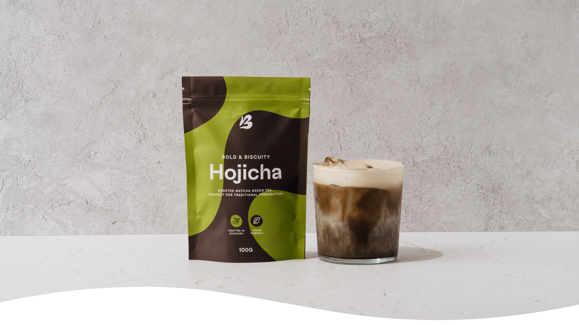 Packet of Blendsmiths Pure Hojicha powder with an iced hojicha latte