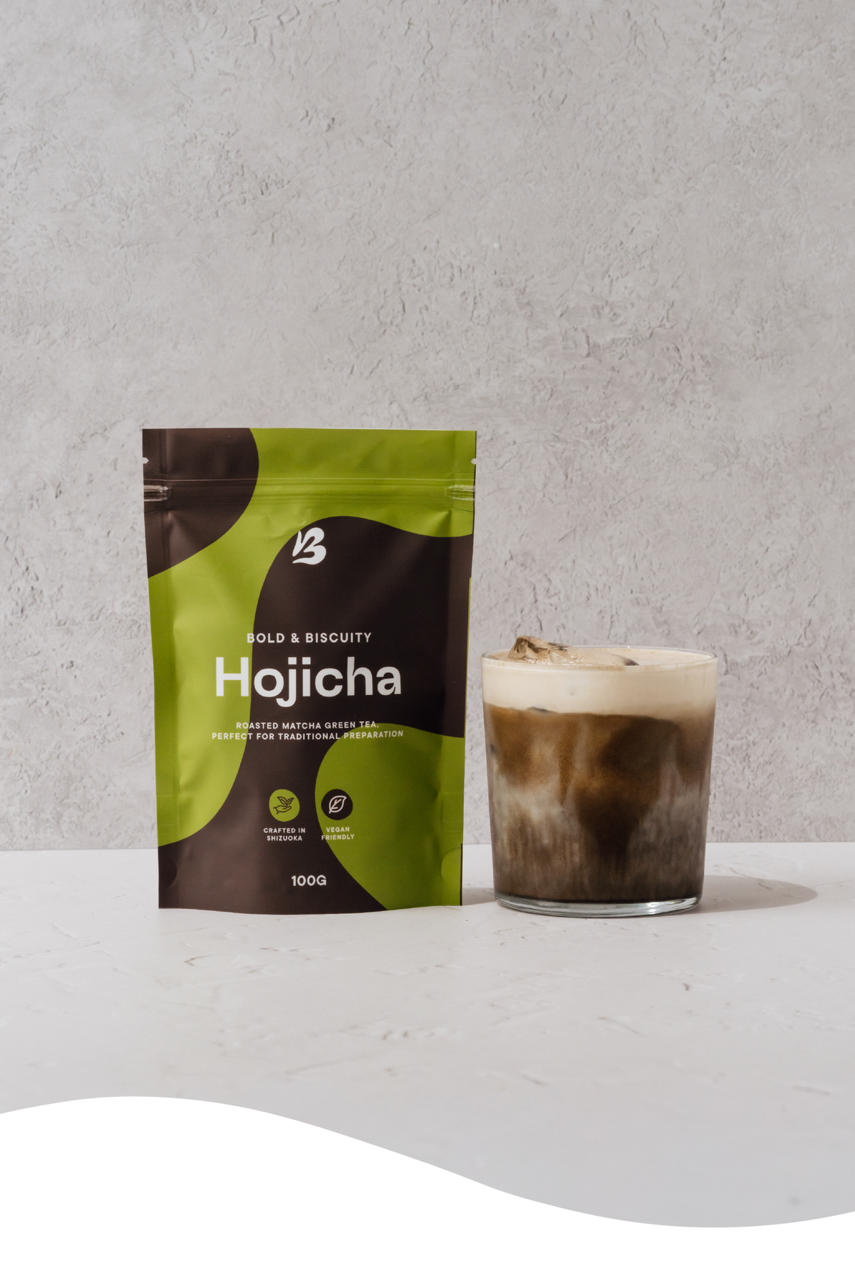 Packet of Blendsmiths Pure Hojicha powder with an iced hojicha latte